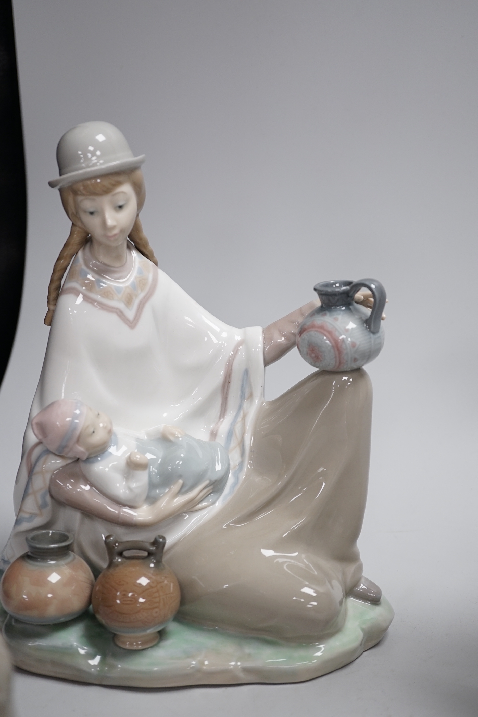 Four Lladro models, a girl potter, girl with ducks, mother and child with pottery and girl with a dog, highest 23.3cm